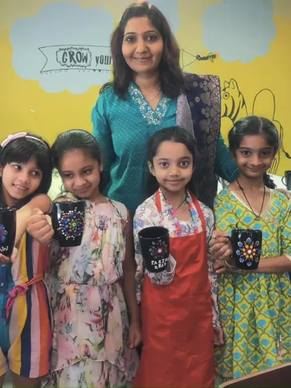 A group of friends posing with me after completing their personalized mugs at Kiara's fun-filled art party.