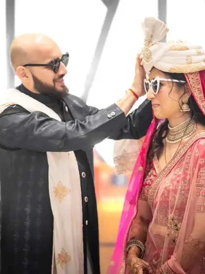 A playful moment between the bride and groom. His gesture of adjusting her sunglasses is both sweet and funny, showing their easygoing connection.