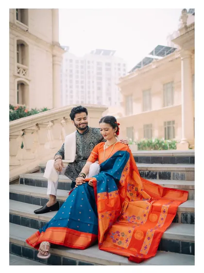 A quiet moment of togetherness on the steps of a grand location. I focus on capturing the natural chemistry between a couple, like the shared glance between Raj and Isha in their beautiful traditional Maharashtrian attire. This is a classic couple portrait that feels both royal and real.