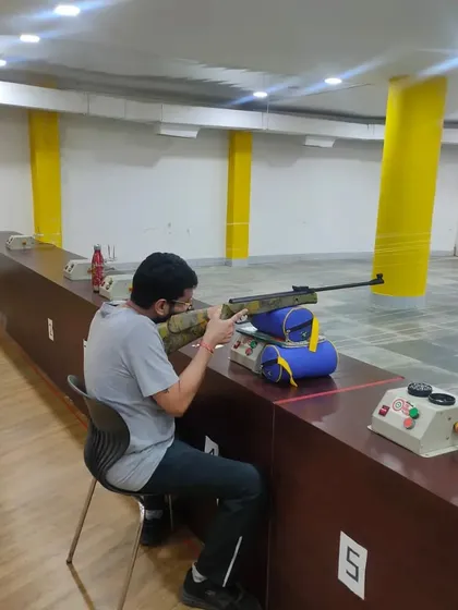 A student practices his aim during a training session. Regular practice is key to improving hand-eye coordination and consistency in shooting.