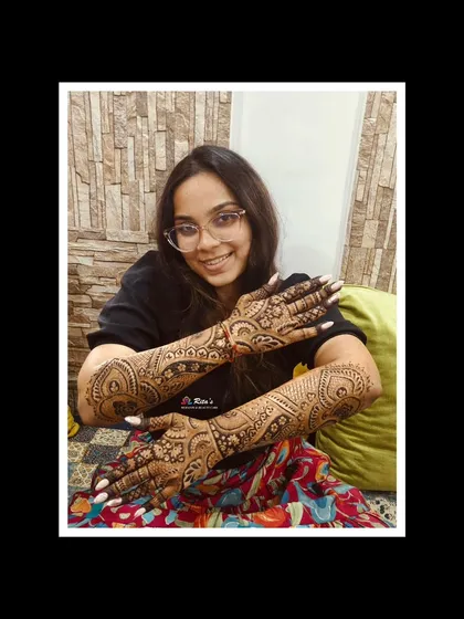 The happy client showing off her stunning Dubai-style mehendi. This style is known for its bold lines and delicate patterns.