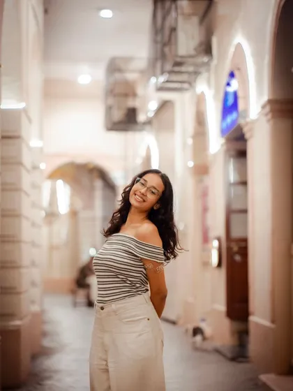 A beautiful portrait taken in a warmly lit alleyway. The leading lines of the corridor draw the eye directly to the subject.