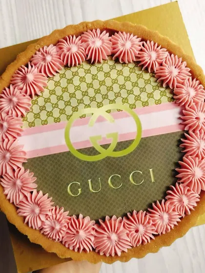 For the fashion lover, I designed this stylish Gucci-inspired chocolate tart. It features the iconic brand pattern and logo, bordered by delicate pink buttercream, making it a chic and delicious statement piece for any celebration.