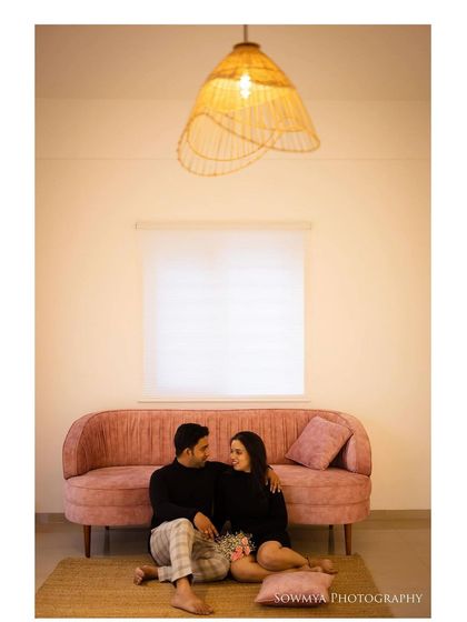 This wider shot shows the cozy and modern aesthetic of our Bangalore studio. The pink sofa and warm lighting create a comfortable setting for a lifestyle couple shoot.