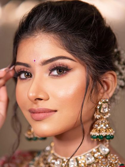 A detailed close-up of the eye makeup. The soft brown tones and sharp winged liner create a captivating gaze that is both classic and alluring.