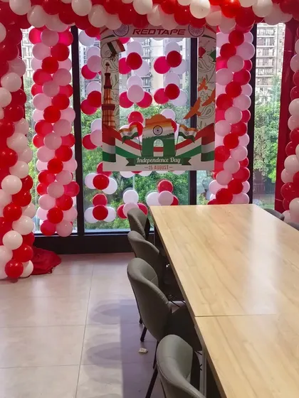This is an example of office party decoration I did for RedTape. I set up a balloon arch in the company's colors and created a custom branded selfie frame for their Independence Day celebration.