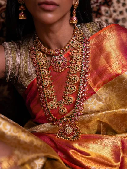 A close-up on the magnificent bridal jewelry, which perfectly complements the golden sheen of the Kanchipuram tissue silk saree.