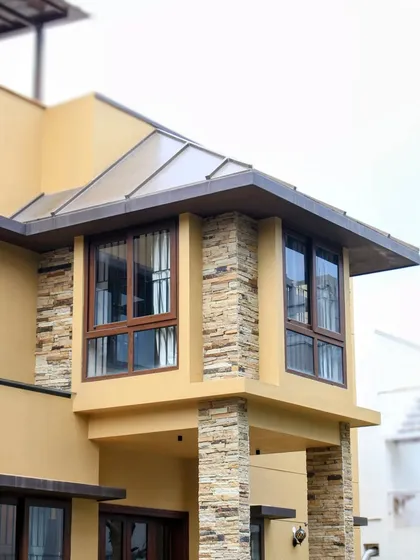 Another angle of the bay window, illustrating how the design maximizes natural light while maintaining the rustic character with stone and wood-framed windows.