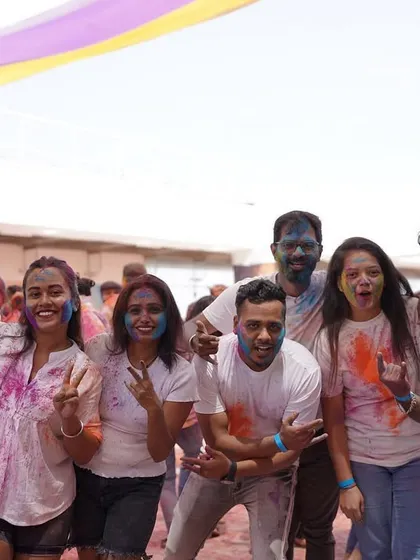 A large group of friends posing together at Holi Utsav. Our festivals are perfect for celebrating with your entire crew.