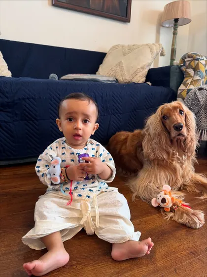 Pablo and Posto sitting together after the Rakhi ceremony, surrounded by their toys and gifts.
