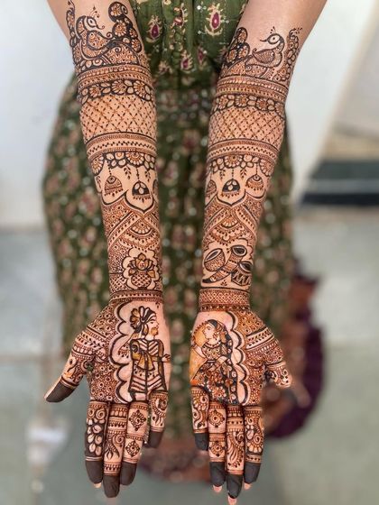 A classic portrait design with the bride and groom on the palms. The arms are decorated with peacock motifs and traditional hanging elements like jhumkas.