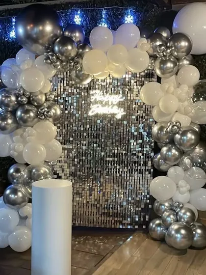 Here is another look at the silver and white shimmer wall setup, this time with fairy lights twinkling in the background. The combination of the reflective sequins and the soft lights makes for an absolutely dreamy and festive atmosphere.