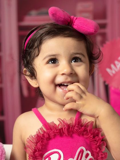 A series of close-up portraits showing the many adorable and happy expressions of a little girl during her Barbie-themed session.
