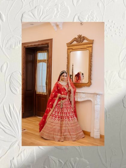 An artistic portrait of a bride in her red lehenga, framed by a textured white floral border.