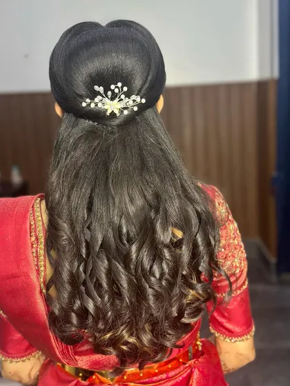 A close-up of beautiful reception curls, adorned with a sparkling accessory. This is a glamorous and elegant hairstyle that is perfect for a modern bride.