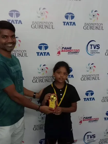 A coach presents a trophy to a young girl at the Fame Badminton Academy tournament in Chennai.