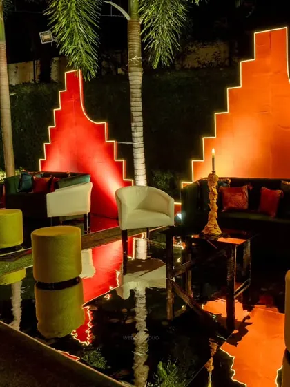 A futuristic lounge area with a bold color palette. We used black mirrored floors to reflect the glowing orange geometric backdrops, creating a sleek and vibrant space for guests.
