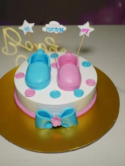 A close-up of a "He or She" gender reveal cake. We capture all the creative details of your baby shower.