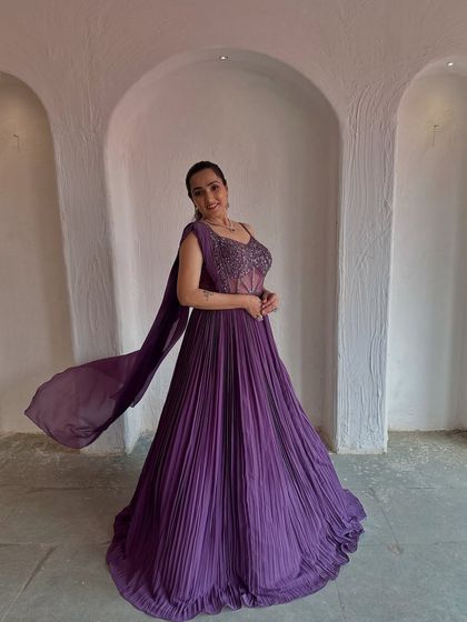 The flowing dupatta of this purple gown adds a touch of drama and elegance. It's a beautiful choice for a reception or cocktail party.