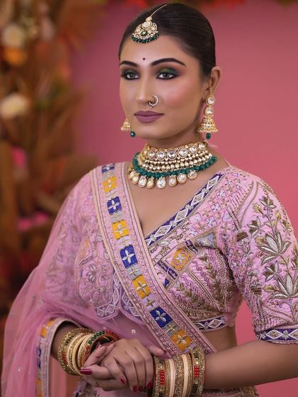 This bride pairs her colourful pink lehenga with a simple but elegant green beaded choker, showing how contrasting colours can work beautifully.