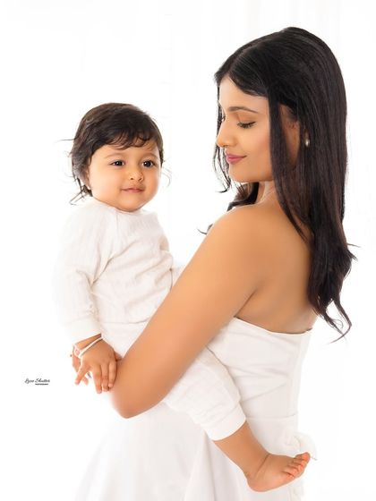 A simple and beautiful mother and child portrait against a clean white background. The focus is entirely on the mother's loving gaze and the baby's sweet face.