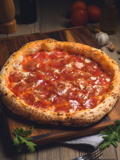 A beautifully styled shot of our Truffle Salami pizza on a wooden board.