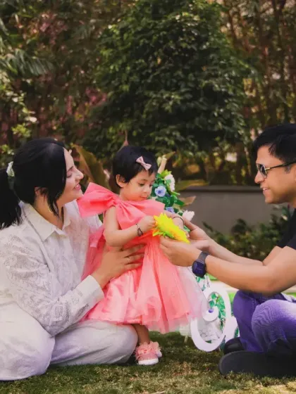 A happy family enjoying a picnic-style setup during an outdoor photoshoot. Natural light and a relaxed setting make for beautiful memories.