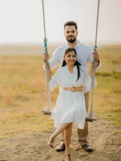 A fun and classic pre-wedding photo on a rustic swing. This shot of Milan and Pranali is playful and sweet, capturing a lighthearted moment.