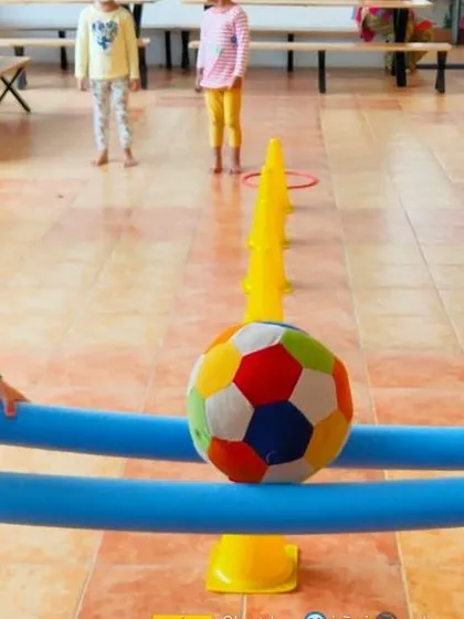 A close-up of two young students concentrating as they learn the art of balance together. This partner activity is a fantastic exercise in focus and cooperative play.