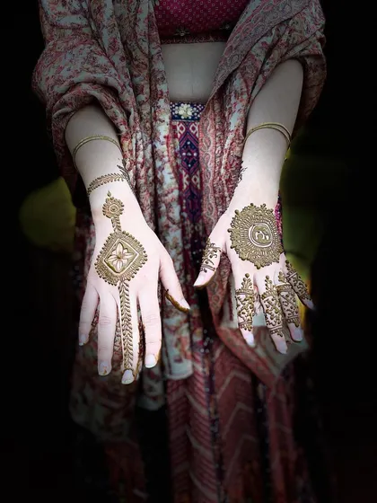 A beautifully edited photo of a client with a modern, minimalist design. The geometric pattern on one hand and the mandala on the other create an artistic contrast.
