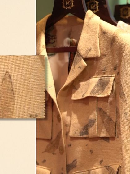 A close-up of a leaf-patterned shacket with a fabric swatch. This highlights the unique texture and print of the material, perfect for a distinctive casual look.