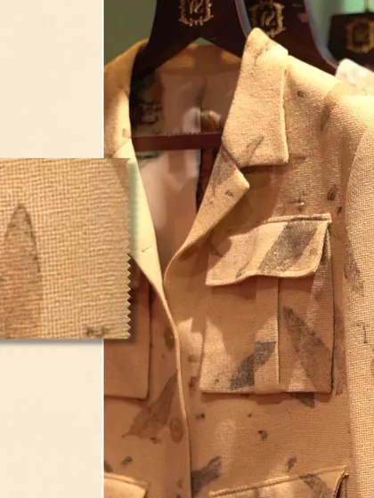 A close-up of a leaf-patterned shacket with a fabric swatch. This highlights the unique texture and print of the material, perfect for a distinctive casual look.