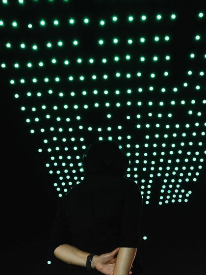 A team member watches the drones form a perfect grid above. This shot, taken on World Photography Day, celebrates the storytellers who capture the magic we create.