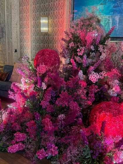 A lush, dense arrangement of pink and purple flowers, showcasing the artistry and abundance of the floral design. The different shapes and textures of the blooms create a visually stunning and luxurious display.