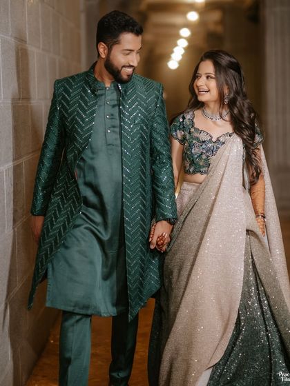 A happy, walking shot of the couple at their Sangeet. Their coordinated green outfits and joyful interaction make for a lovely candid portrait.