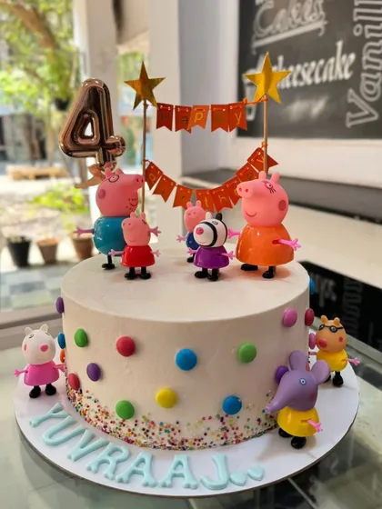 A fun Peppa Pig party on a cake! This design features the whole family as figurines on a simple, colorful polka-dot cake, perfect for a young child's 4th birthday.