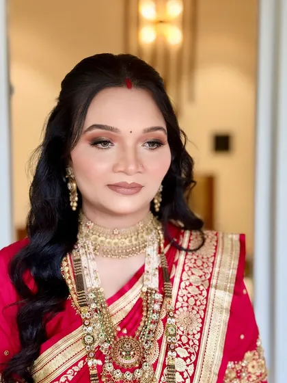 A close-up portrait showcasing the soft glam makeup with a neutral matte lip, which provides a modern touch to her traditional naming ceremony attire.