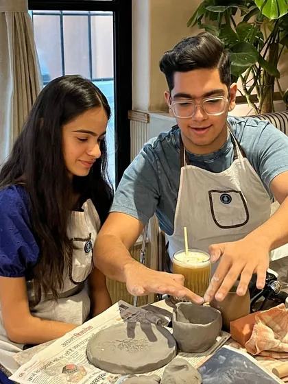 A brother and sister collaborating on a piece. Pottery is a fantastic activity for siblings to do together, fostering teamwork and creativity.