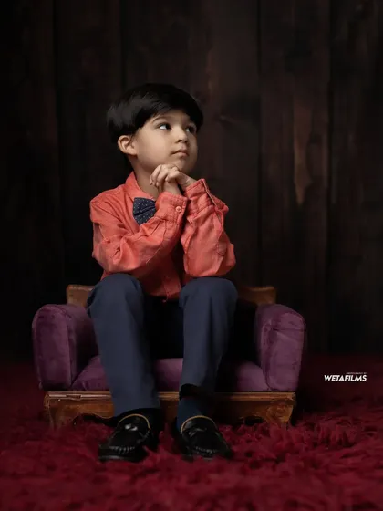 This indoor studio shoot showcases a more dapper and classic look. We use simple props and a dark wood background to create a sophisticated portrait for your child.