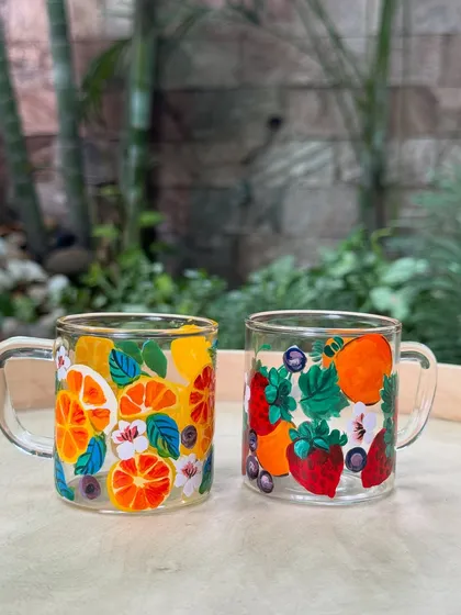 A set of upcycled glass cups painted with a vibrant, fruity theme. We love giving old items a fresh, new purpose.