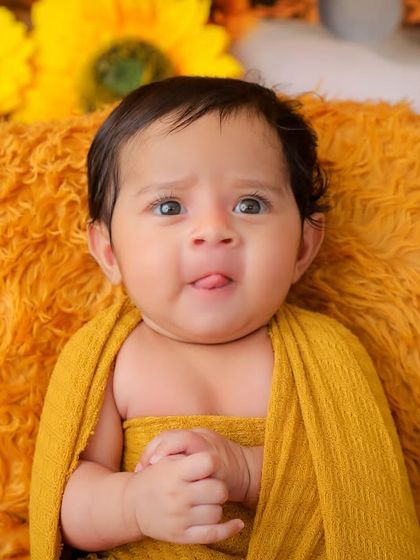 A cheeky little tongue-out moment from this newborn in our sunflower setup. Even the tiniest babies have big personalities, and we love to capture them.