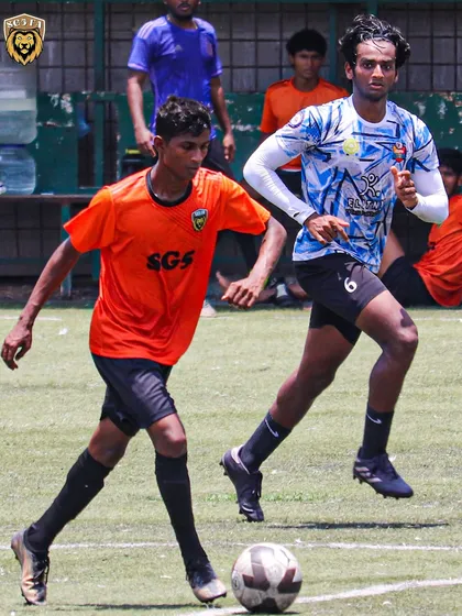 An SG5 player skillfully navigating past a defender during a First Division league game.