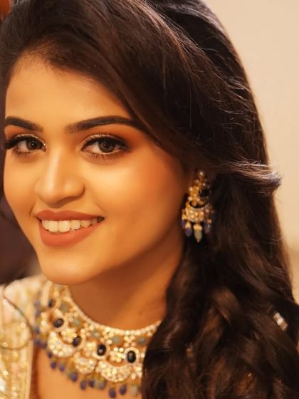 Payal's radiant smile is the centerpiece of this reception look. The makeup is designed to complement her happiness, with warm tones and a touch of sparkle.