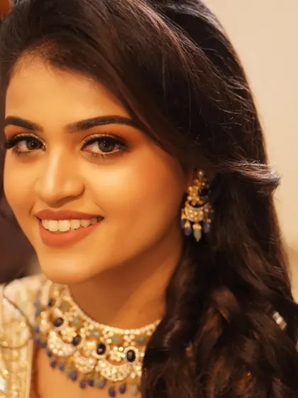 Payal's radiant smile is the centerpiece of this reception look. The makeup is designed to complement her happiness, with warm tones and a touch of sparkle.