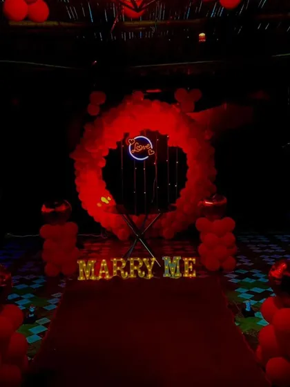 Here is the proposal setup at night, with the lights creating a dramatic and romantic effect. The illuminated "MARRY ME" letters and the neon sign become the main focus in the dark.