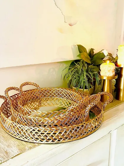 Our gold mirror basket trays come in a set of three nesting sizes. This image shows them displayed on a console table, where they add a touch of opulence and reflect light beautifully.