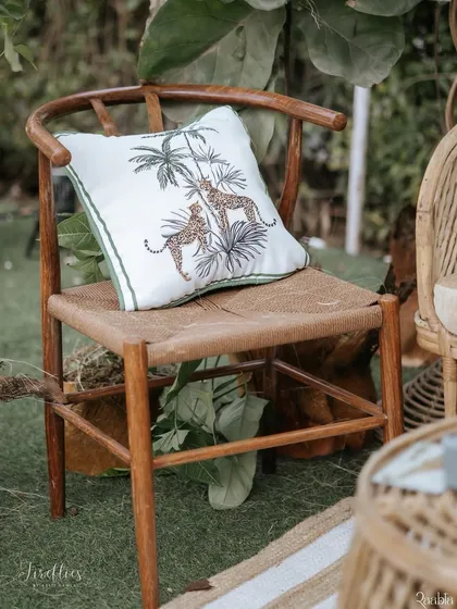 A custom-embroidered cushion featuring a leopard motif, adding a touch of jungle luxe to the seating.
