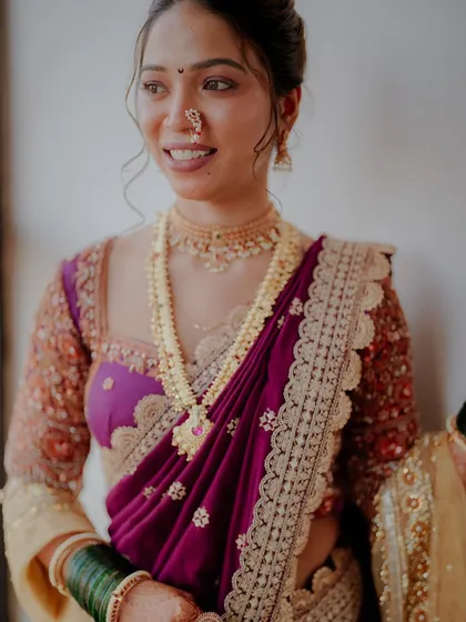 A close-up of the bride's happy expression, showing how the makeup highlights her features, including the traditional nath and bindi.