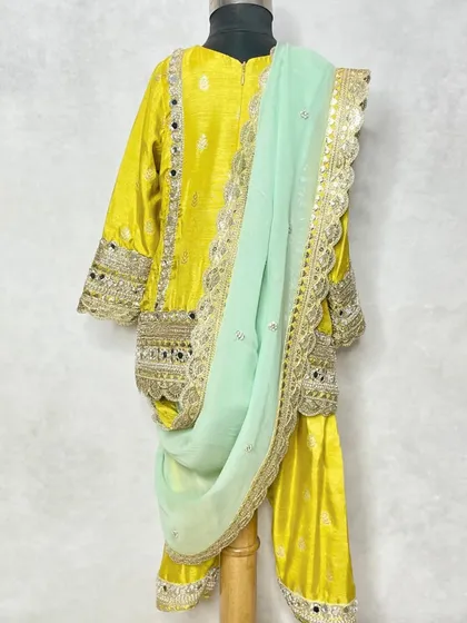 The back view of the yellow mirror work kurta set, showing the detailed craftsmanship.