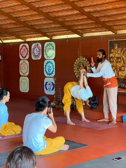 I demonstrate a hands-on adjustment for a standing forward bend, teaching students how to create space in the spine and release tension in the hamstrings.